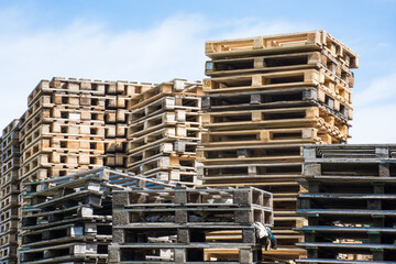 A huge pile of wooden pallets in the warehouse. Industrial and factory concept. 
