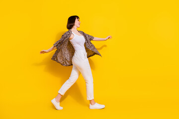 Full body profile photo of sweet lady go wear eyewear shirt trousers sneakers isolated on yellow color background