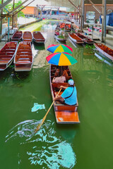 Fototapeta na wymiar Boat man paddling at Damnoen Saduak Floating Market in Ratchaburi Thailand.