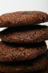 Pile of delicious healthy chocolate cookies on a golden plate and white background