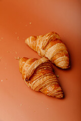 Top view of two appetizing croissants on a beige background