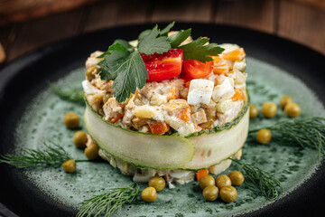 Restaurant garnished russian olivier salad on wooden background