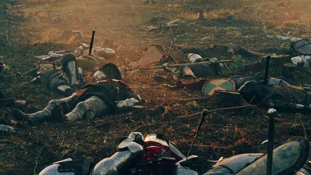After Epic Battle Bodies of Dead and Murdered Medieval Knights Lying on Battlefield. Warrior Soldiers Fallen in Conflict, War, Conquest. Cinematic Dramatic Historical Reenactment. Tracking Moving Shot