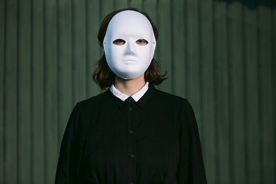 Unrecognizable woman with Halloween mask in street