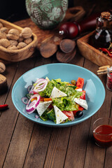 Plate of greek salad with fresh vegetables on wooden decorated background