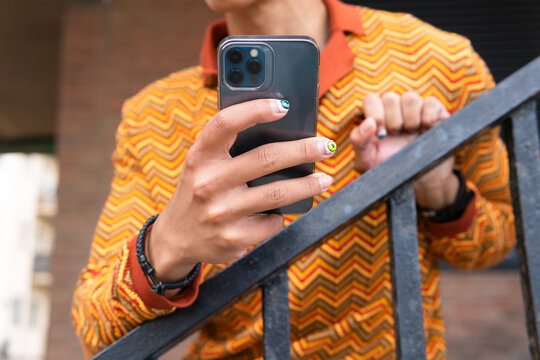 Fancy man with manicure using smartphone