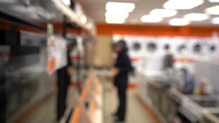 A man chooses a new oven at a home appliance store. Filmed in motion. PAN. Blurred video. Selective focus