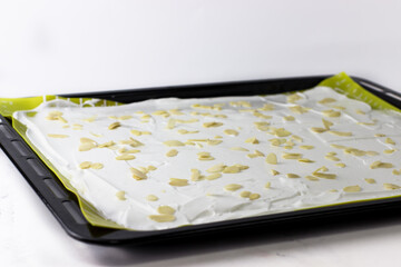 Meringue roll on a baking fairing with pistachio petals
