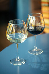 Two glasses of red and white wine on the blue restaurant table