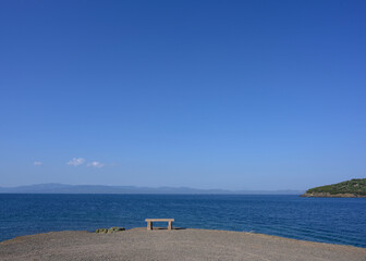 Photo of an empty stone bench overlooking the sea
