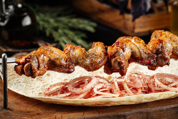 Caucasian chicken wings shashlyq skewers on a wooden background