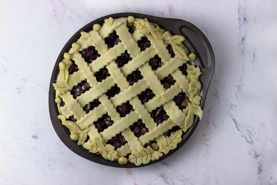 American cherry pie in baking dish on a white background