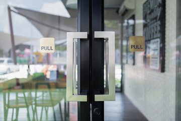 Restaurant door handle bar on glass door - obrazy, fototapety, plakaty