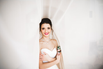 Luxury bride in white dress posing while preparing for the wedding ceremony