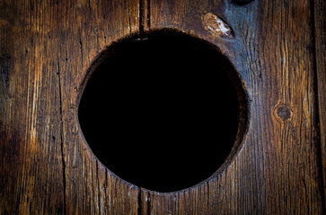 Closeup shot of a round hole in a wooden surface