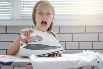 Screaming child with burned skin from iron. Hot iron burns the skin of the hands. child safety precautions