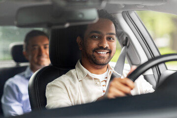transportation, vehicle and people concept - happy smiling indian male driver driving car with passenger