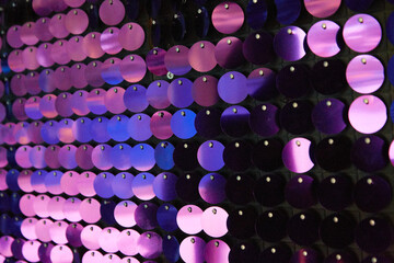shiny texture of the background, a set of round purple sequins sewn on the fabric like fish scales