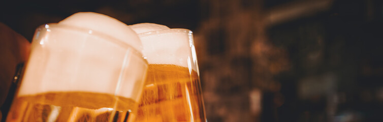 Beer glasses clinking in bar or pub