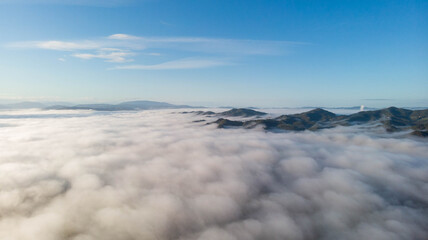 Fog with mountain. Sky with clouds.