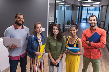 Portrait of diverse group of creative colleagues looking at camera and smiling