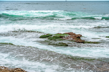 Beautiful turquoise ocean waves with rocks