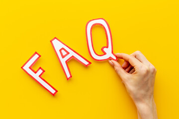 Hands with faq - frequently asked questions - made of paper