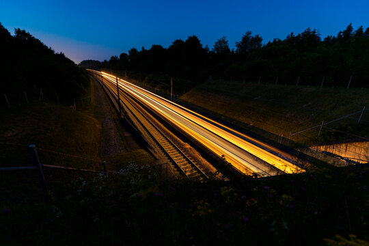 schweizer bahn in der nacht f&auml;hrt sehr schnell in ein tunnel durch wald