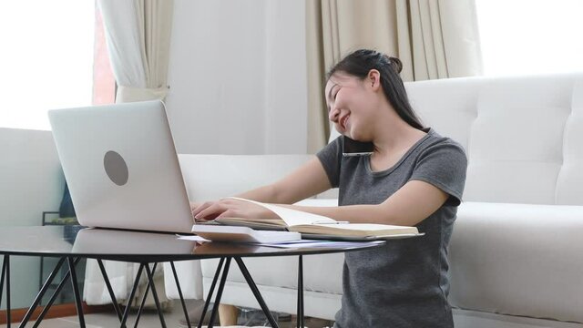 Woman talking on the phone ,Working in a laptop with a smiling face, Business Cell Phone Conversations, Write notes in a notebook as a reminder, Working at home, Home lifestyle, Stay home.