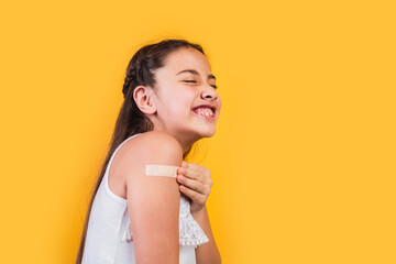 Portrait of a little girl smiling after receiving a vaccination.