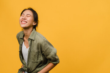 Portrait of young Asia lady with positive expression, smile broadly, dressed in casual clothing over yellow background. Happy adorable glad woman rejoices success. Facial expression concept.