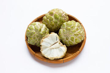 Custard apple in bamboo basket on white background.