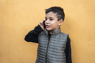 Portrait of a little boy talking on a smartphone.