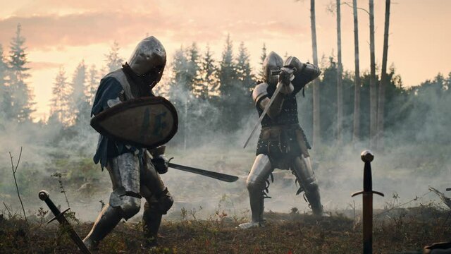 Epic Battlefield: Two Armored Medieval Knights Fighting with Swords. Dark Ages Army Warfare. Action Battle of Armed Warrior Soldiers, Killing Enemy. Cinematic Historical Reenactment. Slow Motion