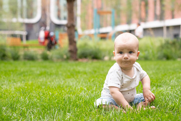 Little baby on fresh green grass outdoors