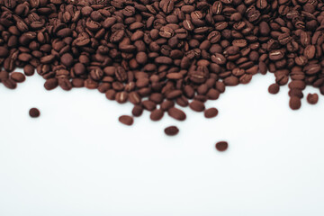 Aromatic dark brown coffee beans isolated on white background. Top view with copy space for your text
