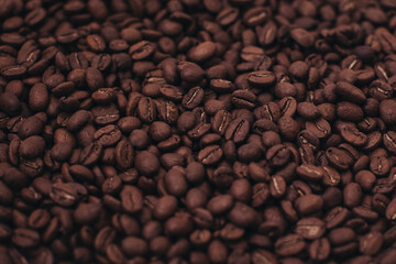 Aromatic dark brown coffee beans background. Top view. Photo with film grain effect