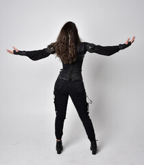 Full length portrait of young woman with natural brown hair,  wearing black leather scifi outfit...