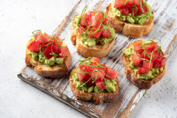 avocado and tomato crostini. Bruschetta toast with mashed avocado