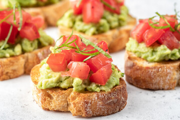 avocado and tomato crostini. Bruschetta toast with mashed avocado