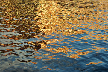 golden glare on blue water texture