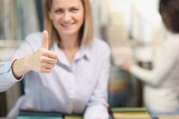 Woman shopper smiling showing thumbs up gesture in store