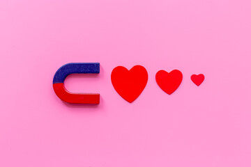 Love and relashionship concept. Horseshoe magnet with heart shapes