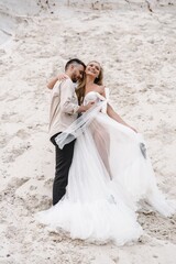 Naklejka premium Beautiful wedding couple bride and groom at wedding day outdoors at ocean beach. Happy marriage couple o