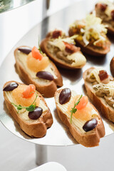 Beautiful catering banquet buffet table. Banquet service. Assorted bruschetta on white plate. High quality photo