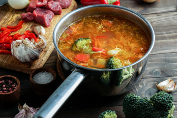 hot soup in a saucepan is steaming. with beef and vegetables. hearty, nutritious dish. dinner