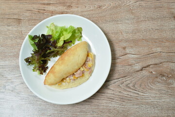 puff bread stuffed chicken sausage with sour cream sauce and vegetable on plate