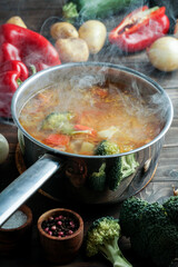 hot soup in a saucepan is steaming. with beef and vegetables. hearty, nutritious dish. dinner