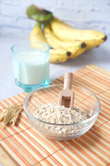 oats flakes , glass of milk and banana on table 