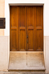 Entrance or front door of a private majorcan house with an extra wooden cover over the bottom end...